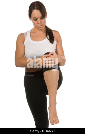 Donna in abbigliamento sportivo gamba facendo tratto isolato su bianco Foto Stock