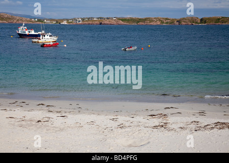 Piccole barche ancorate nel suono di Iona, con una spiaggia di sabbia bianca di Iona davanti e Fionnphort, Mull, in background Foto Stock