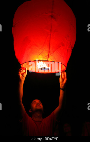 L'uomo il lancio di sky lantern nel cielo notturno Foto Stock