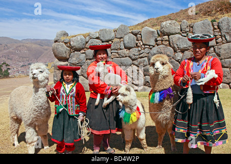 Donna indigena e le ragazze con alpaca, Sacsayhuaman, Cuzco, Perù, Sud America Foto Stock