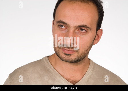 Con barba perso nel pensiero che guarda lontano contro uno sfondo bianco Foto Stock
