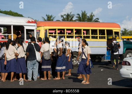 La scuola dei bambini imbarco vivacemente colorato bus in Apia, Samoa Occidentali Foto Stock