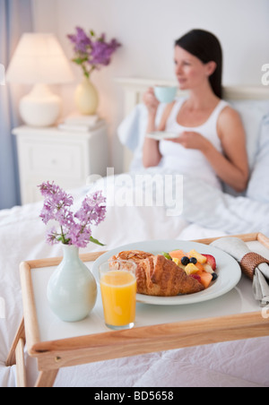 Un uomo portando una donna colazione a letto Foto Stock