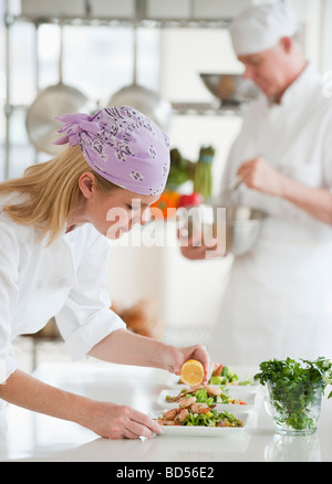 Chef rendendo insalata in una cucina Foto Stock