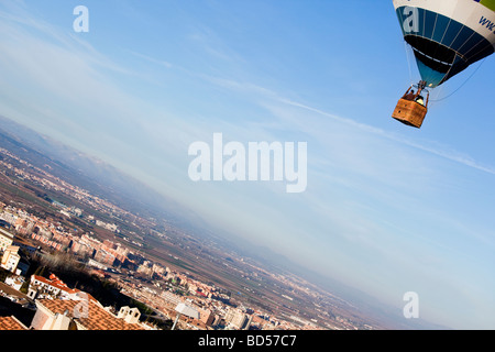 Irriconoscibile la gente nel cestello di palloncino volare sulla città Foto Stock