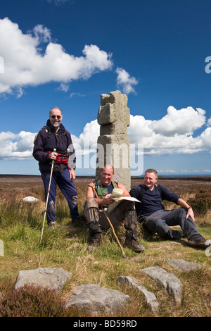 Walkers sul Lyke Wake a piedi Lilla Cross Fylingdales Moor North Yorkshire più antiche del North York Moors eretta nel 625 Foto Stock