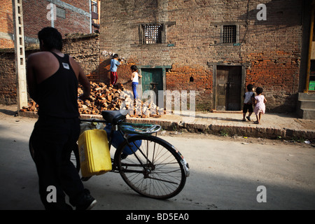 L'uomo trascinando la sua bicicletta sulla strada, Nepal Foto Stock