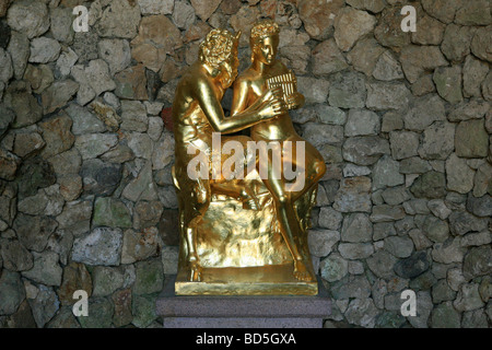 Statua dorata di Pan insegnamento il pastore Daphnis, per riprodurre il panpipes all'interno della grotta di Peterhof Palace a San Pietroburgo, Russia Foto Stock