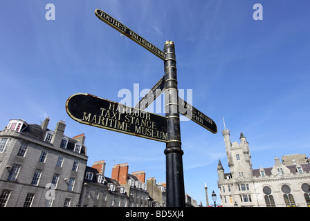 In vecchio stile street segni nel Castlegate di Aberdeen, Scozia, con l'edificio della Cittadella in background Foto Stock