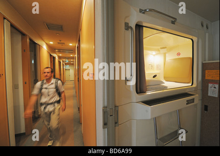 Uomo che cammina nel corridoio di hotel Foto Stock