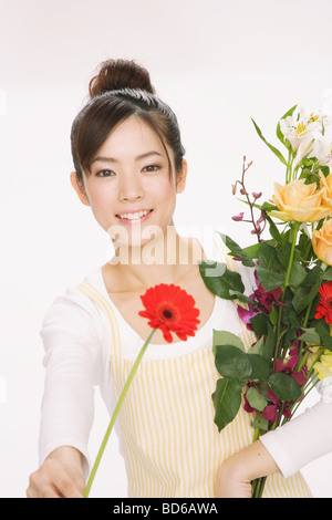 Giovane donna attraente dando un fiore Foto Stock