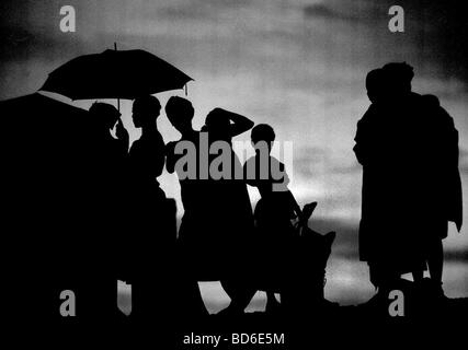 Le donne tornare dal lavoro al tramonto trapiantare il riso è un compito estenuante nel piccolo villaggio di Dembel Jumpora in Guinea Foto Stock