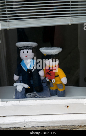 Un paio di tessuti lavorati a maglia peluche in una finestra in St ives cornwall Foto Stock