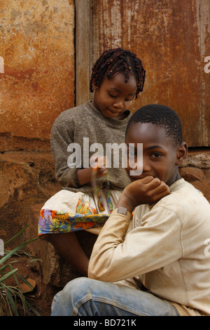 Un ragazzo e una ragazza davanti a una porta, Bafoussam, Camerun, Africa Foto Stock