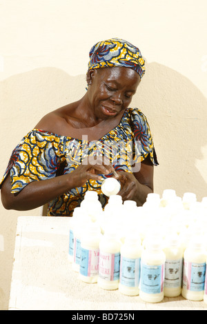 Donna che lavorano nella produzione di yogurt in una latteria, Maroua, Camerun, Africa Foto Stock