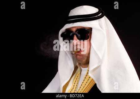 Uomo che indossa un costume di Sheikh e fumare un sigaro Foto Stock