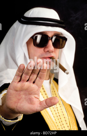 Uomo che indossa un costume di Sheikh e fumare un sigaro Foto Stock
