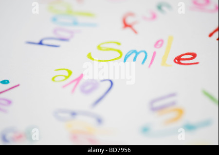 Parola colorata sorriso, felice e amore su un foglio di carta scritto in matite colorate Foto Stock