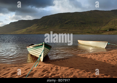 Due le barche a remi utilizzato per la pesca legato sulle rive di un lago irlandese in Galway Mayo regione Irlanda Foto Stock