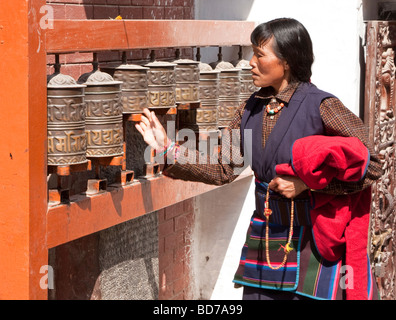 Bodhnath, Nepal. Adoratore buddista ruotando la ruota di preghiera. Foto Stock