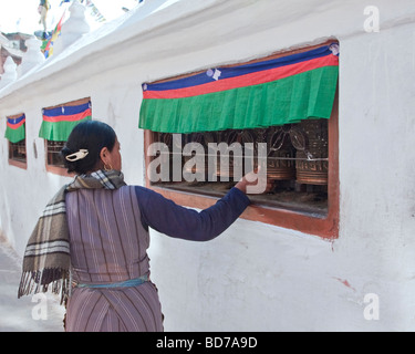 Bodhnath, Nepal. Adoratore buddista ruotando la ruota di preghiera. Foto Stock