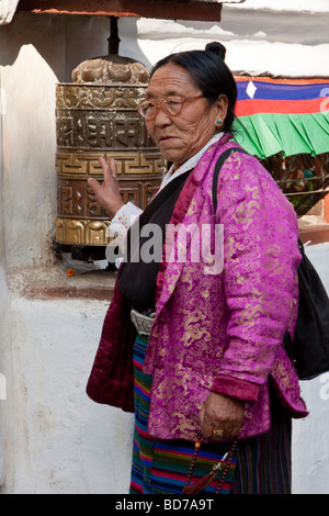 Bodhnath, Nepal. Adoratore buddista ruotando la ruota di preghiera. Foto Stock