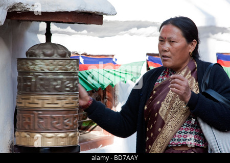 Bodhnath, Nepal. Adoratore buddista ruotando la ruota di preghiera. Foto Stock