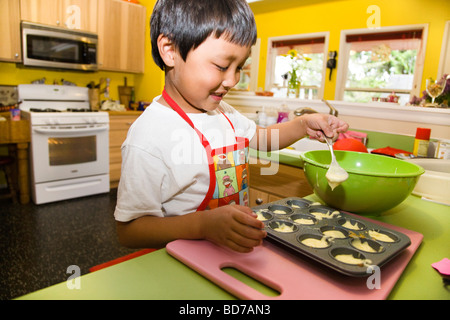 Ragazzo giovane rendendo i tortini Foto Stock