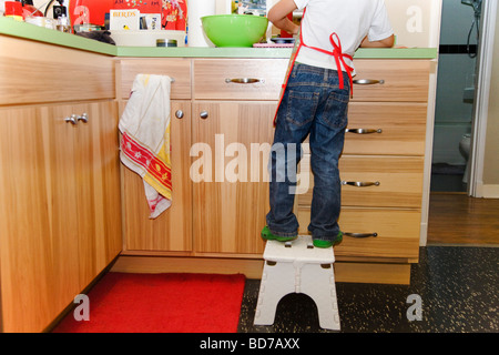 Ragazzo giovane rendendo i tortini Foto Stock