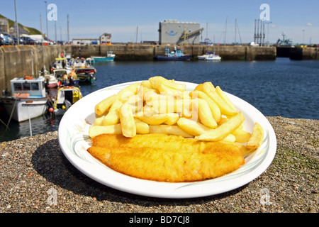 Una piastra di britannica tradizionale pesce e patatine sul lato del porto a Scrabster, Scotland, Regno Unito Foto Stock