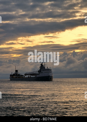 Michigan's Grandi Laghi Lago Huron freighter all'alba in uscita del Lago Huron in una stupefacente cloudscape Foto Stock