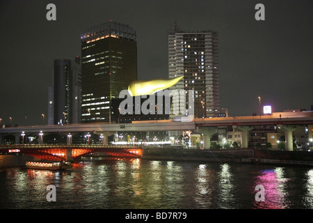 Una fiamma oro in cima alla disegnato Asahi brewery accanto al fiume Sumida il quartiere di Asakusa Tokyo Giappone Foto Stock