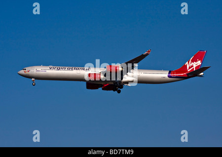 Virgin Atlantic Airbus A340-600 di nome 'Miss Behavin' con landing gear down. Foto Stock