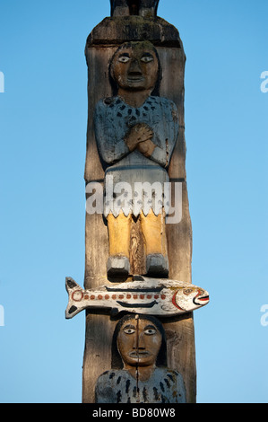 Un totem raffigurante un salmone e due persone che orna il centro tribali area sulla Lummi Prenotazione indiana nei pressi di Bellingham, WA Foto Stock