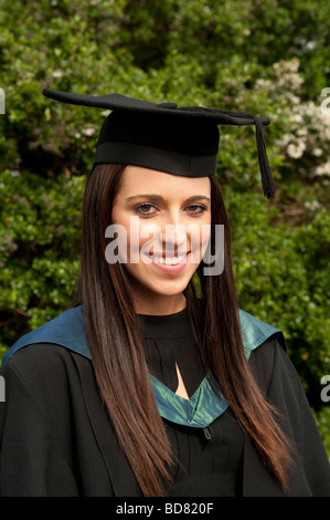 Una donna studente a Aberystwyth University indossando il tradizionale abito di accademici e di mortaio board sul giorno di graduazione Wales UK Foto Stock