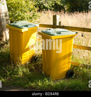 Due giallo impennarsi in contenitori con coperchi di colore verde in una zona rurale lane, Wales UK Foto Stock