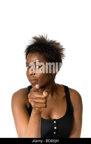 Chiudere verticale fino studio ritratto di un attraente donna africana puntando il dito in un gesto aggressivo Foto Stock