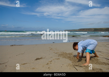 Un bambino di sei anni ragazzo scava nella sabbia su Sennen Cove Beach in Cornwall, Regno Unito 2009 Foto Stock