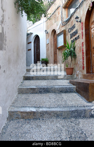 Taverna e passi lungo la strada stretta a Lindos Rodi Grecia DODECANNESO Foto Stock