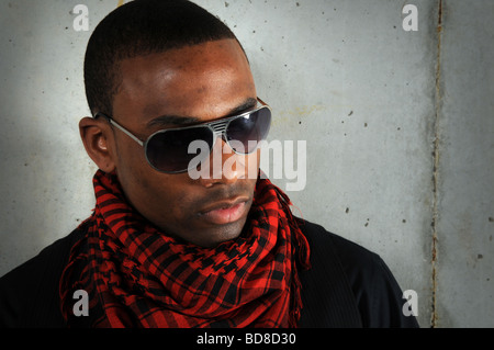 Ritratto di African American appoggiata contro la parete di cemento Foto Stock