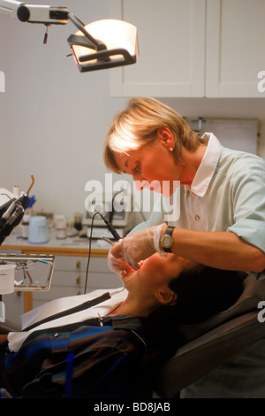 Donna dentista lavorando sul paziente in studio dentistico Foto Stock