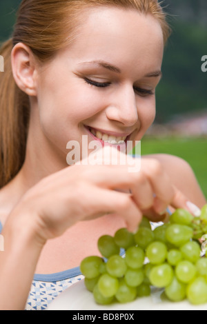 Giovane donna di mangiare uva Foto Stock