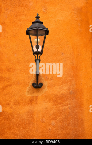 Tradizionale montato a parete in stile vecchia città strada lampada su una parete in terracotta Foto Stock