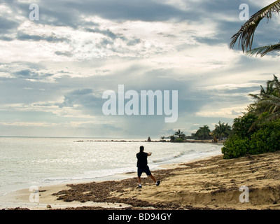 Un uomo solitario practice tai chi su una spiaggia dopo una tempesta tropicale Foto Stock