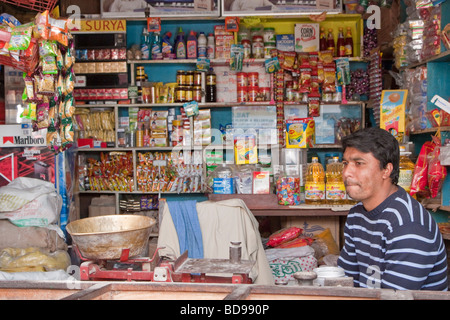 Bodhnath, Nepal. Il proprietario del negozio, fornitore di prodotti alimentari e articoli vari. Foto Stock