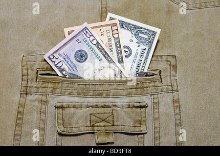 Tre differenti valute US dollar note nella tasca di un paio di pantaloni khaki Foto Stock