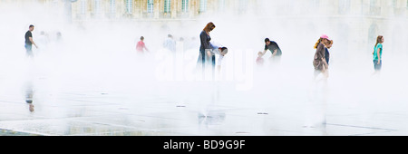 Gruppi separati di persone in un ambiente nebbioso Place de la Bourse Bordeaux Francia Foto Stock