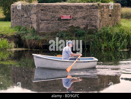 Un vecchio uomo remare una barca Foto Stock