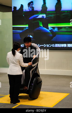 Un uomo viene incaricato di guidare una Toyota concept futuristico di triciclo presso lo showroom di Toyota Auto Salon a Tokyo Giappone Foto Stock