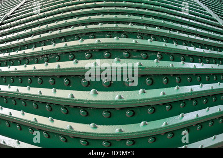 Rivetti & teste di rivetto nella trave in acciaio costruzione sul lato inferiore del ponte ferroviario closeup come modello astratto immagine di sfondo manipolato & invertiti Foto Stock